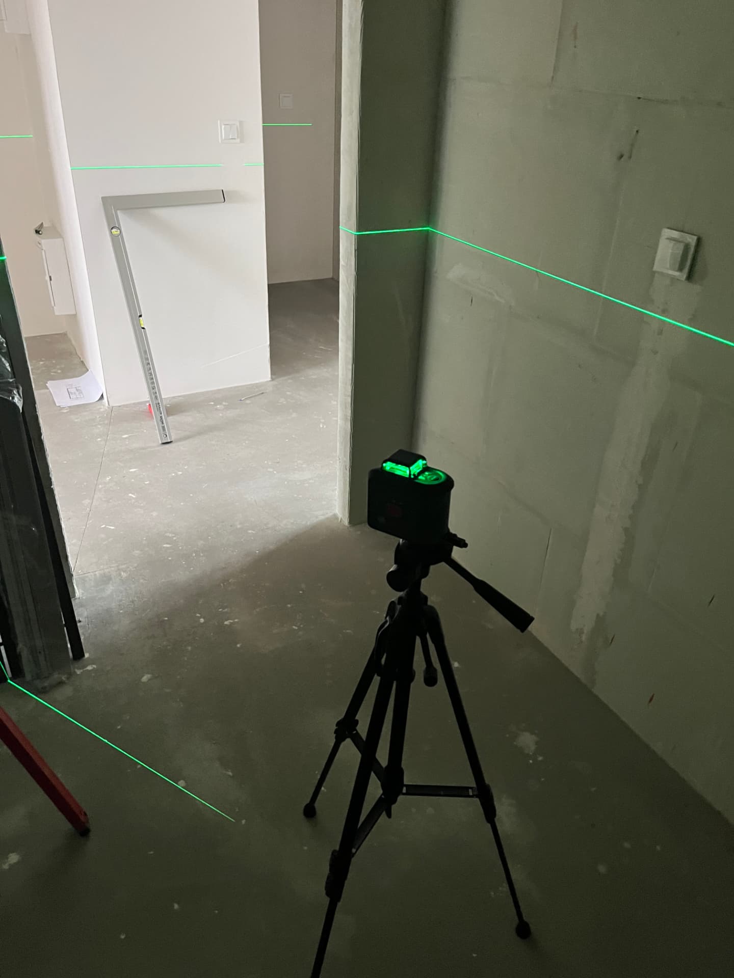 Laser 360° na statywie z liniami pomiarowymi na ścianach